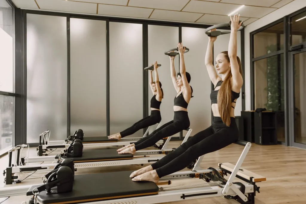 Reformer Pilates class in a studio with large windows
