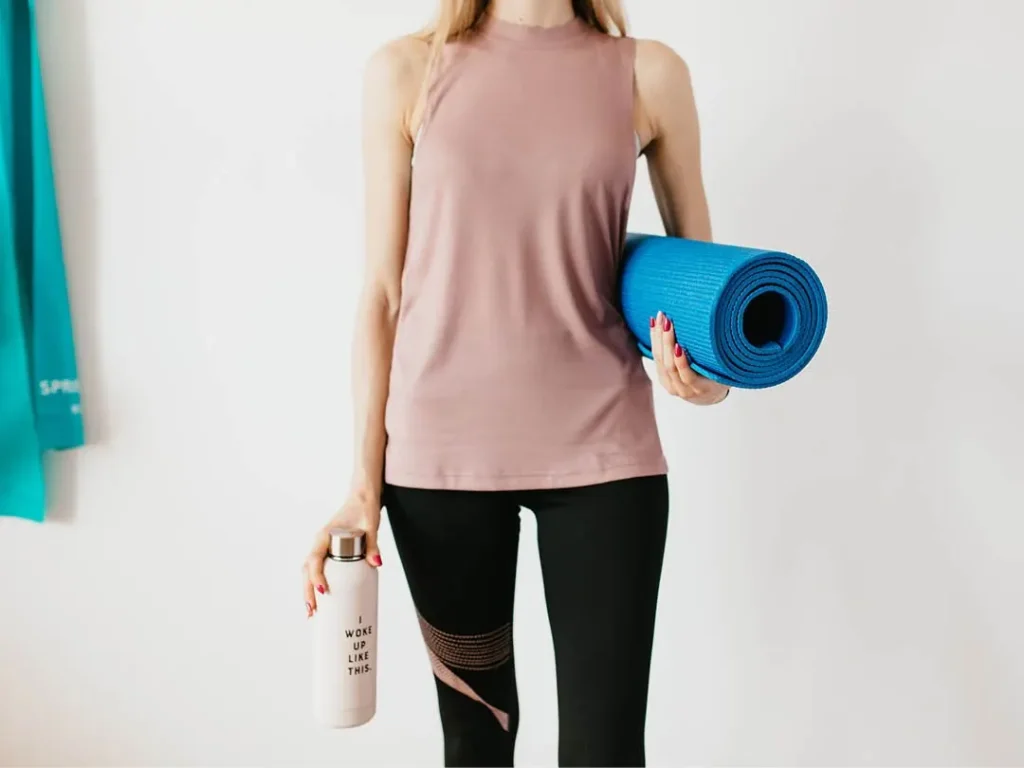 Woman holding a rolled exercise mat, from Mike Redshaw
