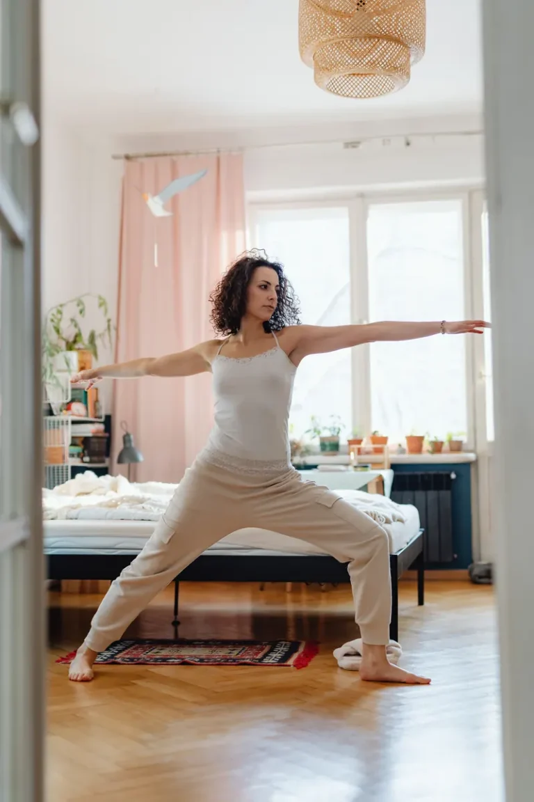 Woman stretching on an exercise mat in a bright bedroom